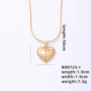 Detailed view of gold heart letter pendant necklace with delicate chain and sparkle stone.
