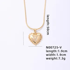 Gold heart pendant necklace detail featuring a crystal letter V and delicate snake chain.