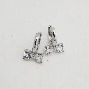 Close-up detail view of elegant silver hoop earrings featuring sparkling heart-shaped zircon bows.