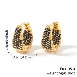 Macro view of gold U-shaped earrings with pavé-set black cubic zirconia stones