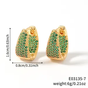 Close-up of gold-plated U-shaped hoop earrings with green cubic zirconia pave setting