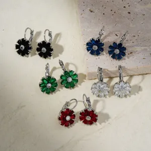 Set of five vibrant flower drop earrings in various gemstone colors on stone slab