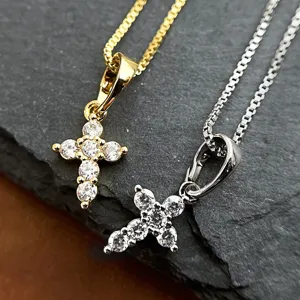 Close-up of vintage gold and silver cross pendant necklaces on dark stone surface