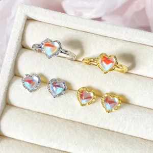 Nahaufnahme von einem herzförmigen Mondstein-Schmuckset mit Ringen und Ohrsteckern