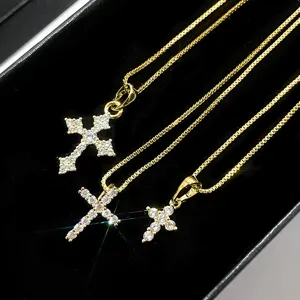 Macro view of sparkling gold cross pendants with iced-out zircon stones on box chains.
