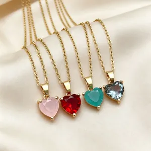 Close-up detail of multicolored heart-shaped zircon pendant necklaces on shiny satin background.