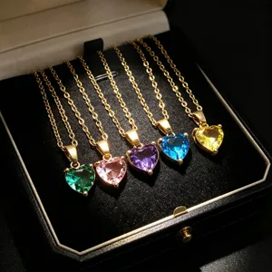 Detail view of multi-color heart crystal pendant necklaces arranged neatly in black jewelry box.