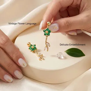 Detailansicht goldener Ohrringe mit grüner Blume und Blättern aus Zirkonia-Stein