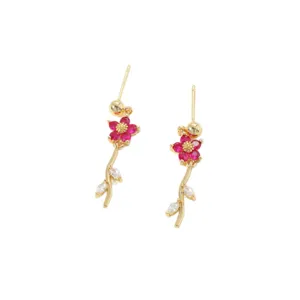 Nahaufnahme der goldenen Blumenohrringe mit rosa Steinen und Zirkonia-Blättern