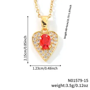 Detailed view of a gold-colored heart pendant necklace with a red stone and zirconia