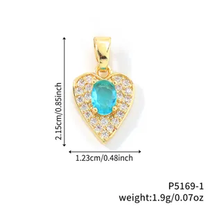 Detailed view of a gold heart pendant with central aqua stone and zircon border