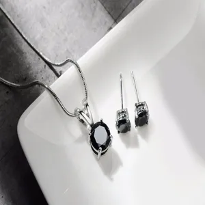 Primo piano di uno splendido set con collana con ciondolo in pietra nera rotonda e orecchini.