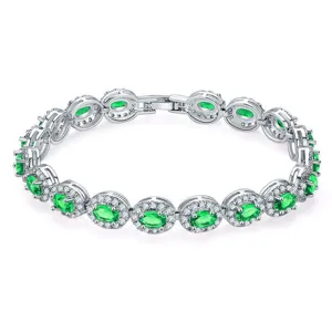 Close-up of elegant bracelet featuring oval green zircons and sparkling halo diamond settings