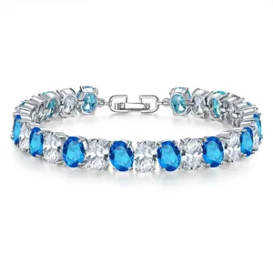 Close-up of elegant luxury bracelet with oval blue and clear zircons in silver finish