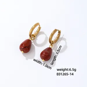 Gold tone hoop earrings with red teardrop stone pendants, chic and elegant jewelry item.
