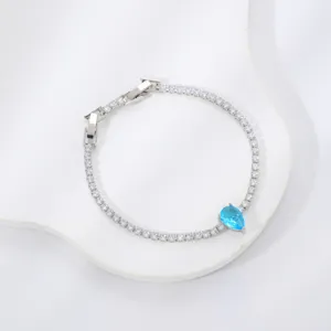 Detailed close-up of a silver-toned bracelet featuring a brilliant blue teardrop zircon