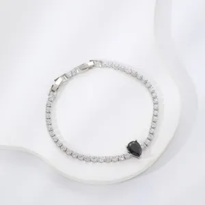 Detailed view of silver-tone zircon tennis bracelet with a black teardrop stone pendant
