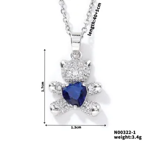 Close-up of sparkling cubic zirconia bear necklace with blue heart and size measurement details