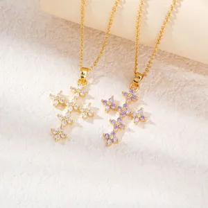 Pendentifs croix en trèfle doré avec des pierres de zircone blanches et violettes en détail