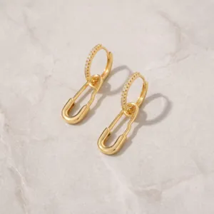 Detailed macro view of 16K gold plated safety pin earrings featuring cubic zirconia stones