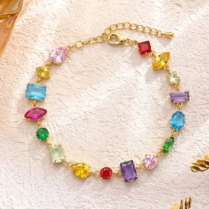 Vista dettagliata di un bracciale con gemme multicolori e catena dorata di tendenza.