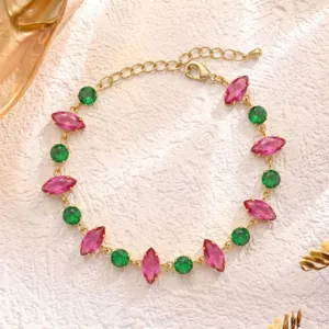 Vista macro dettagliata di un elegante bracciale in oro con pietre marquise verdi e rosa