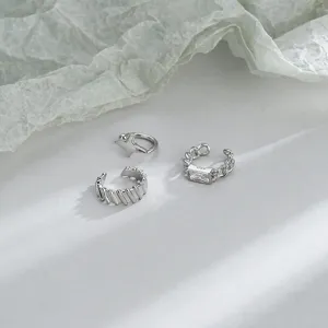 Detailed view of three minimalist silver ear cuffs with star and zircon crystal designs