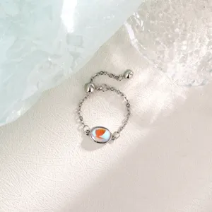 Detailed macro view of an iridescent oval crystal set on a silver adjustable chain ring