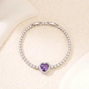 Detailaufnahme eines silbernen Armbands mit lila Herzstein und Zirkonsteinen.