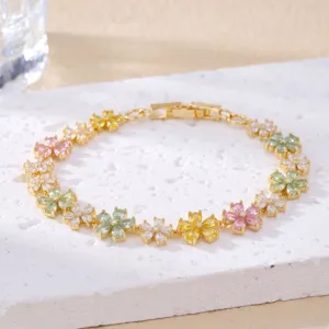 Close-up of a delicate gold-tone bracelet with vibrant multi-colored crystal flower charms