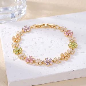 Close-up of multi-colored floral zircon bracelet on white textured stone plate