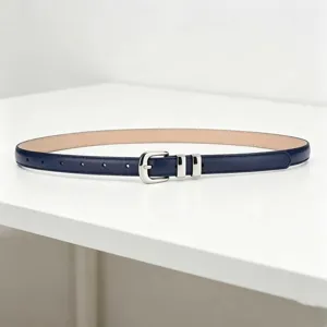 Detailed view of a minimalist women's thin dark blue leather belt with silver metal buckle.