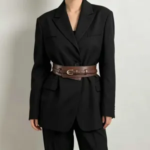 Detailed view of wide leather belt worn with black blazer, showcasing stylish wrap design.