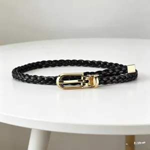 Black braided thin belt with gold metal buckle, detail view of womens dress waist accessory.