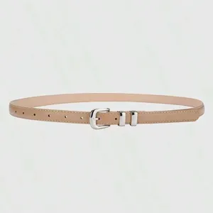 Close up detail of minimalist women thin beige belt featuring polished silver metal buckle.