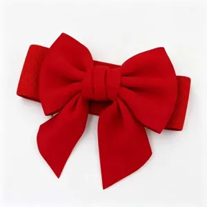 Detail view of a vibrant red elastic waist belt featuring a large decorative bow.
