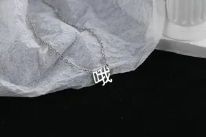 Gros plan détaillé d'un collier minimaliste argenté avec un pendentif en chinois.