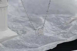 Gros plan d'un collier argenté avec un pendentif original en caractère chinois 'O'.