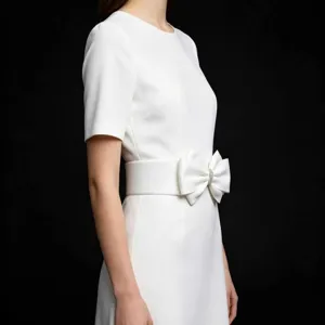Detail shot of wide elastic waist belt featuring a sparkling rhinestone bow for dress styling.