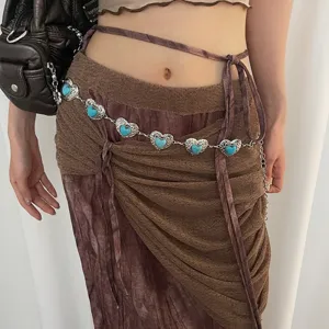 Vintage metal waist chain with heart-shaped turquoise stones shown in a detail shot.