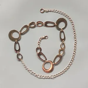 Detailed view of the rose gold metal waist chain featuring interlocking geometric oval links.