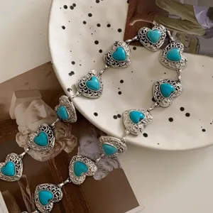Detailed view of retro metal waist chain with heart-shaped turquoise stones
