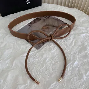 Women's brown PU leather knotted belt, stylish dress and sweater accessory detail view.