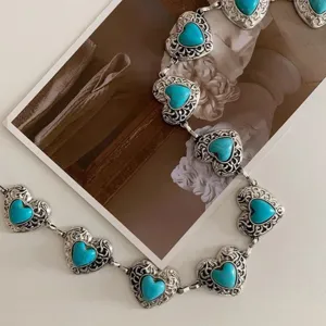 Detailed view of vintage silver waist chain with heart-shaped turquoise filigree charms.