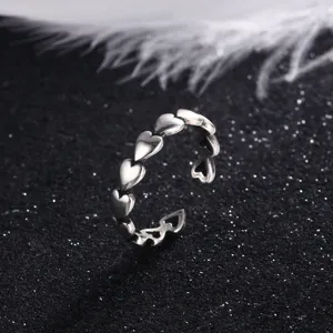 Detail shot of a vintage Thai silver open ring featuring a row of embossed heart shapes
