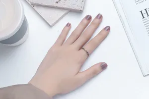 Detailed macro view of a retro geometric hollow silver ring worn on a person's finger