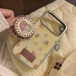 Detail view of the creamy yellow teddy bear patterned phone case with matching heart grip