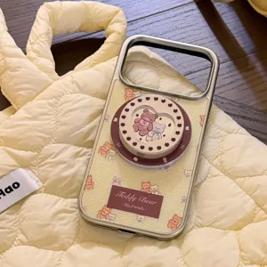 Detail view of a cream yellow iPhone case featuring a magnetic teddy bear heart pop-grip