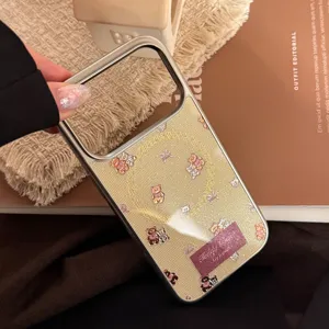 Detailed view of cream-colored iPhone case with cute teddy bear pattern and metallic frame.