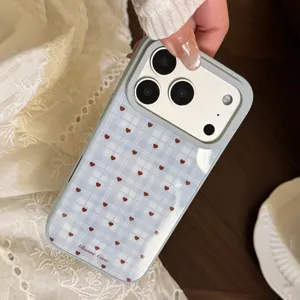 Vue détaillée d'une coque iPhone à carreaux avec petits cœurs rouges et fond bleu